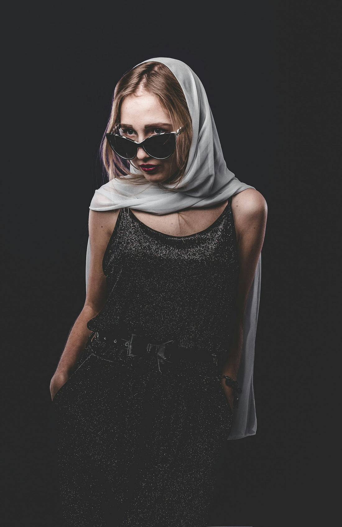 woman in black sleeveless dress wearing black sunglasses