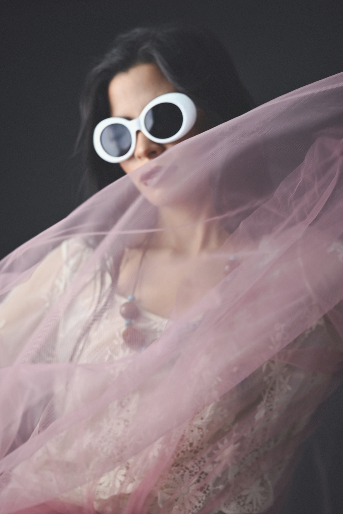 A woman wearing sunglasses and a pink dress