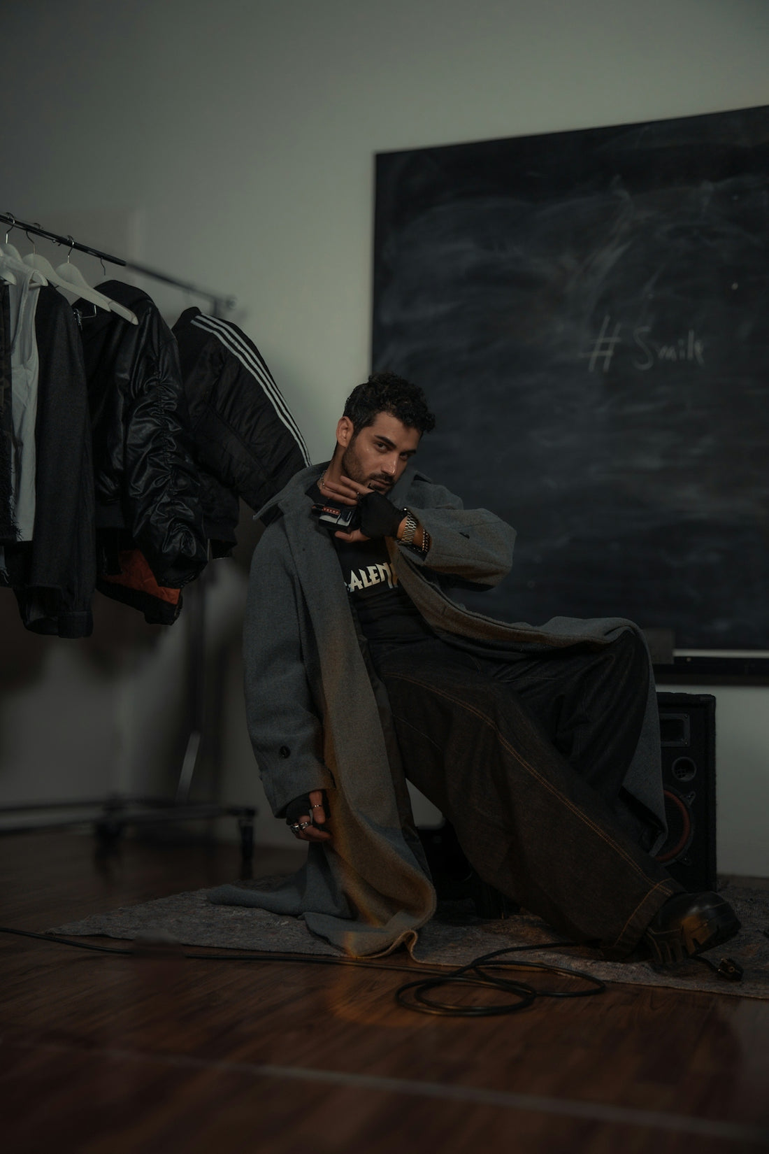 A man poses in a fashion-forward outfit.