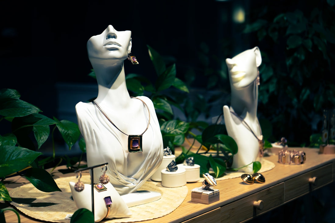 Jewelry displayed on mannequins and stands with plants.
