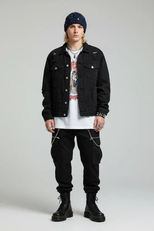 Person wearing a black denim jacket, white t-shirt, black pants, and black boots on a gray background